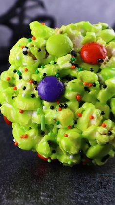 a green broccoli and candy wreath on a black table with other items around it