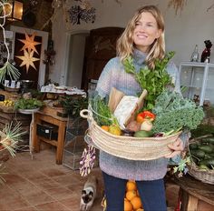 a woman holding a basket full of vegetables