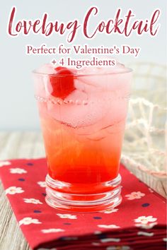 a red drink in a glass sitting on top of a table next to a napkin