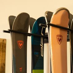 several skis are lined up on a rack