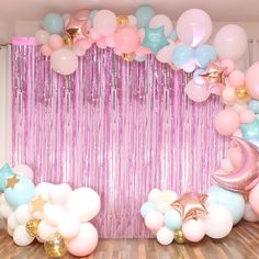 a room filled with balloons and streamers on the wall next to a wooden floor