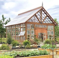 a large wooden greenhouse with lots of plants in it