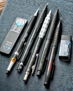 four pens and two batteries on a table