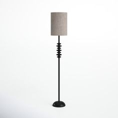 a lamp that is sitting on top of a white surface with a light shade over it