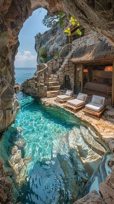 an outdoor swimming pool surrounded by rocks and water