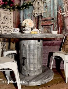 two chairs and a table in front of a wall with an old door painted on it