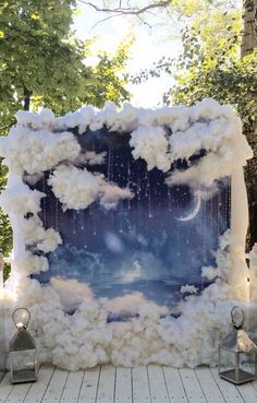 an art piece made out of clouds and stars in the sky with lanterns around it