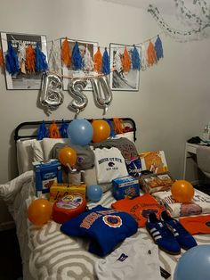 a sports themed bedroom with balloons and gifts on the bed, including t - shirts