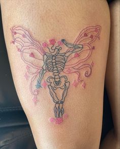 a woman's thigh with a skeleton and flowers tattoo on the side of her leg