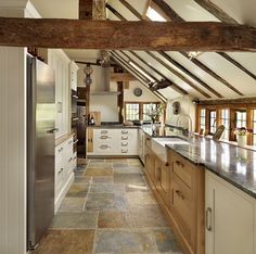 a kitchen with stone flooring and wooden beams