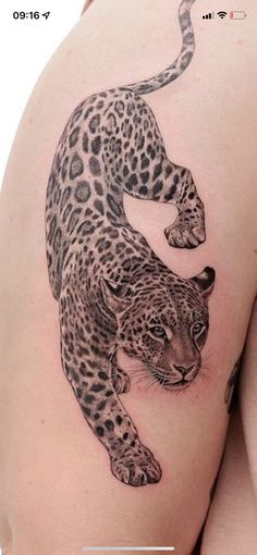 a woman's thigh with a tattoo of a leopard on it