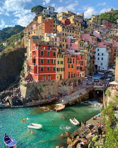 people are swimming in the water next to colorful buildings