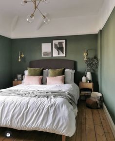 a bedroom with green walls and white bedding