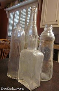 three empty glass bottles sitting on top of a wooden table