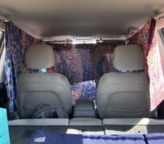 two seats in the back of a van with an area rug on the floor and carpeted walls