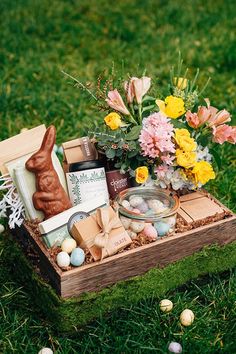 a wooden box filled with lots of different items on top of a grass covered field