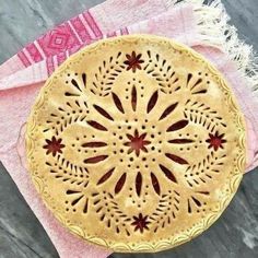 a pie sitting on top of a table next to a pink napkin and some scissors