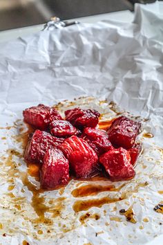 strawberries are sitting on top of wax paper in the middle of some sort of dish