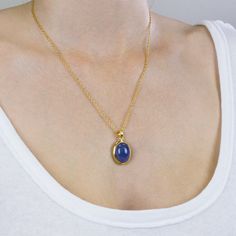 A delicate balance of rich blue and violet, this gem has fine crystal inclusions and an exquisite luster. Wearing this deep blue-hued beauty will add an elegant touch to any outfit. Known as the ‘stone of magic’ it brings its wearer the confidence to turn ideas into reality. Bringing the “will” to start and enhancing from beginning to end. This Tanzanite cabochon stone necklace is also great for Communication and Protection. Stone Origin: ﻿Tanzania Measures Approximately: 22 x 18 mm Materials: Hand Crafted 925 Sterling Silver with a 14k Yellow Gold Vermeil Finish and Gold Fill Box chain Please Note: If you would like to purchase a different chain please purchase pendant only and click here. All pieces shipped within 48 hours from our Del Mar Gallery. Oval Sapphire Necklace With Cabochon Cut, Oval Sapphire Cabochon Necklace, Blue Oval Necklace With Gemstone Accents, Elegant Sapphire Necklaces With Natural Stones, Elegant Sapphire Jewelry With Large Stone, Sapphire Necklaces With Natural Stones, Elegant Lapis Lazuli Oval Pendant Jewelry, Sapphire Tanzanite Birthstone Necklaces, Sapphire Necklace With Natural Stones