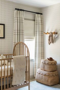 a baby's crib in the corner of a room with striped wallpaper