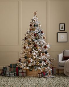 a decorated christmas tree in a living room with presents on the floor next to it