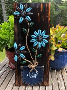 a wooden box with blue flowers painted on it and some succulents in the background