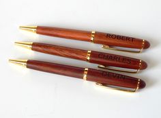 three wooden pens with writing on them sitting next to each other