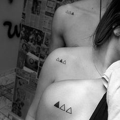 two women with matching tattoos on their bodies, one has an arrow and the other has a triangle