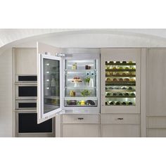 an open refrigerator in a kitchen with lots of food on the shelves and door opened