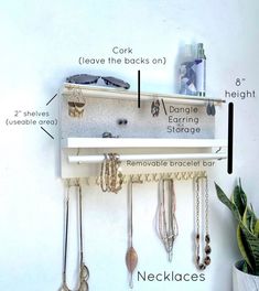 a white shelf with jewelry hanging from it's sides and labeled parts attached to the wall