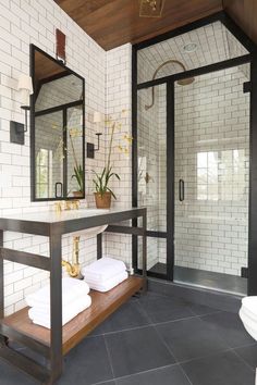 a white tiled bathroom with black and gold accents