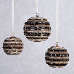 three ornaments hanging from strings on a wall