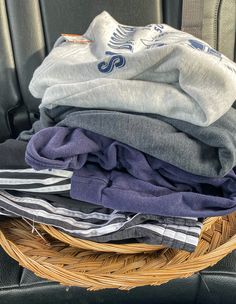 a wicker basket filled with clothes in the back seat of a car