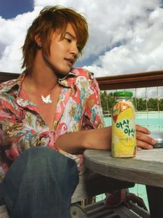 a man sitting at a table with a can of orange juice in front of him