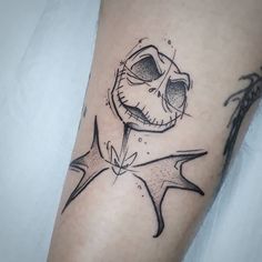 a black and white photo of a tattoo on someone's leg with an evil face