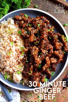 a plate filled with meat and rice on top of a wooden table next to broccoli