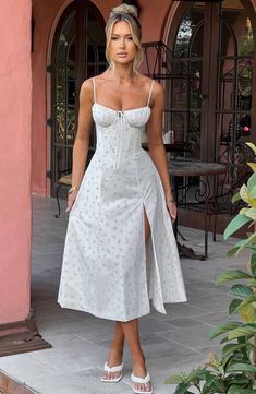 The dreamy Deanna dress is ultra feminine, made in our premium woven cotton blend fabric that feels as good as it looks. With a corseted bodice to cinch the waist, the bust is gathered with a drawstring tie for a super pretty finish. The midi skirt is complete with a thigh high split for a little bit of sexiness. Style it up with an effortless knot and heeled mules.



Colour: Blush Floral Print.

Premium woven cotton blend fabric.

Corseted bodice.

Gathered bust.

Drawstring at the bust.

Thig Homecoming Dresses Corset, Midi Dress Wedding Guest, Dresses Flowy, European Summer Outfits, Ultra Feminine, Maxi Dress Sale, Sparkle Dress, Dresses By Length, Formal Dresses Prom