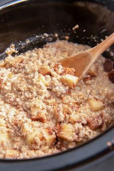 a wooden spoon stirring oatmeal in a slow cooker