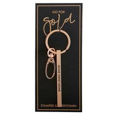 a keychain with the words go for gold on it and a black background