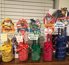 several small vases filled with candy and paper cutouts