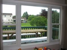 a window with two benches in front of it and a picnic table outside the window