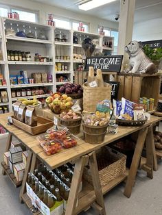 a store filled with lots of different types of food and drinks on wooden tables in front of shelves