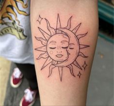 a sun and moon tattoo on the left arm, with eyes closed to the side