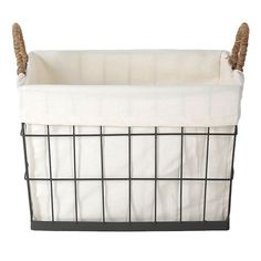 a black wire basket with white linen lining and rope handles on the bottom, holding a blanket