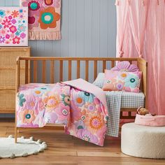 a child's bedroom with pink and blue walls, flowers on the bedding