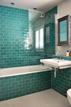 a bath room with a sink and a bath tub next to a mirror on the wall