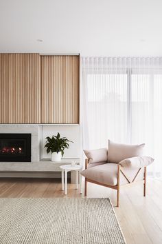 a living room with a couch, chair and fire place in front of a window