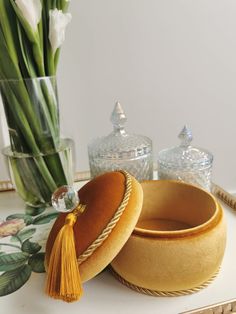 two hats sitting on top of a table next to a vase with flowers in it