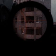 a view through a magnifying glass looking at an apartment building in the distance