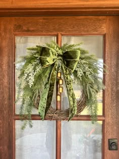 a wreath on the front door is decorated with greenery